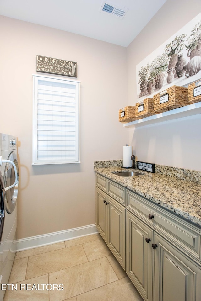 laundry room with light tile patterned flooring, a sink, visible vents, baseboards, and cabinet space