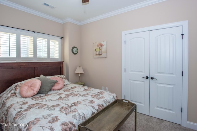 bedroom with a closet, visible vents, carpet flooring, and ornamental molding