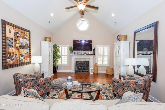 living room with a fireplace, ceiling fan, wood finished floors, high vaulted ceiling, and baseboards