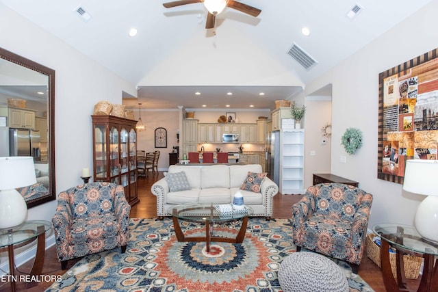 living area with a ceiling fan, visible vents, and wood finished floors