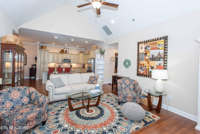 living area with visible vents, baseboards, and wood finished floors