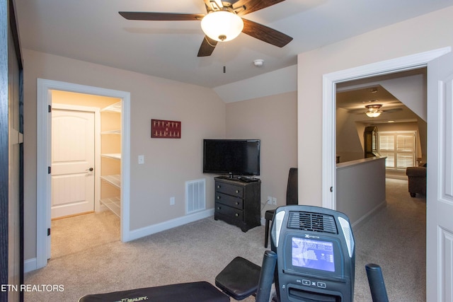 exercise area featuring carpet, visible vents, vaulted ceiling, and baseboards