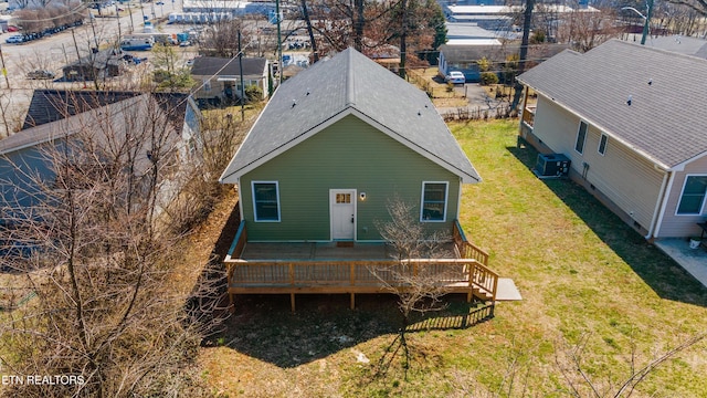 rear view of property featuring a deck, a lawn, and central air condition unit