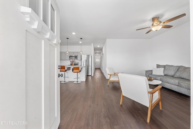 living area with ceiling fan, dark wood finished floors, and recessed lighting