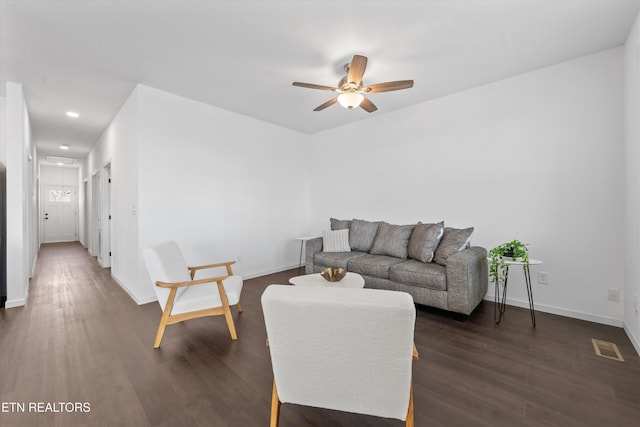 living room featuring visible vents, dark wood-type flooring, attic access, a ceiling fan, and baseboards