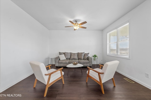 living area featuring dark wood-style floors, a ceiling fan, visible vents, and baseboards