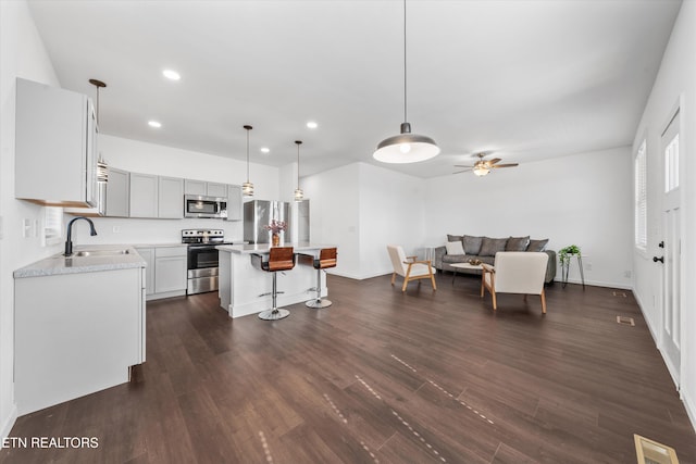 kitchen with dark wood-style floors, appliances with stainless steel finishes, a sink, and visible vents