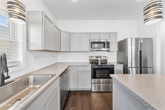 kitchen with stainless steel appliances, light countertops, dark wood-type flooring, and a sink