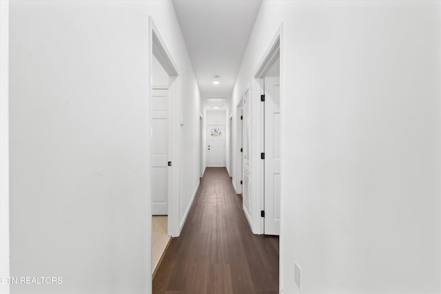 hall with baseboards and dark wood-style flooring