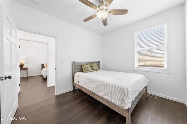 bedroom with ceiling fan, dark wood-style flooring, and baseboards