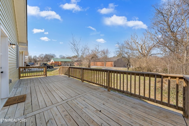 wooden deck featuring a lawn