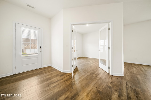 entrance foyer featuring baseboards, visible vents, and wood finished floors