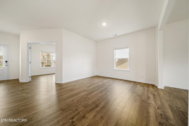 unfurnished living room with dark wood-style floors, recessed lighting, and baseboards