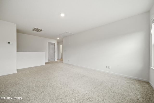 spare room featuring attic access, visible vents, baseboards, light colored carpet, and recessed lighting