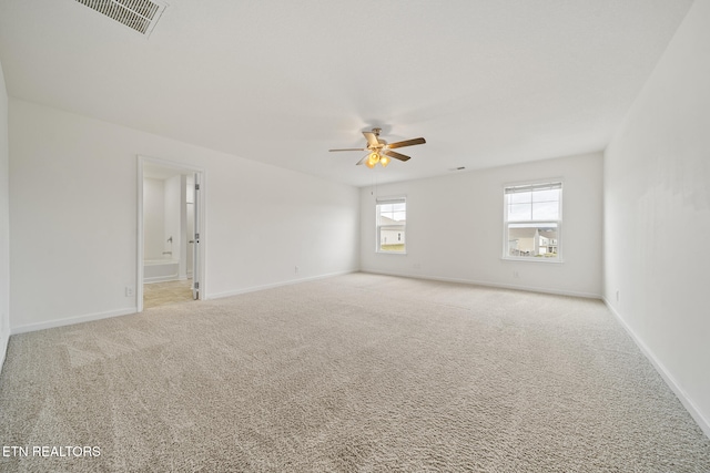 carpeted empty room featuring baseboards, visible vents, and a ceiling fan