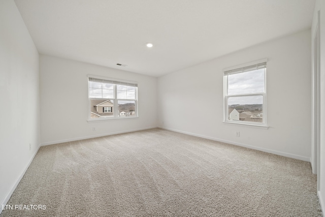 spare room featuring carpet, visible vents, baseboards, and recessed lighting