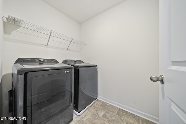 washroom with laundry area, baseboards, and separate washer and dryer