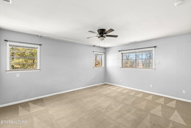 spare room featuring ceiling fan, carpet flooring, visible vents, and baseboards