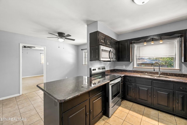 kitchen featuring appliances with stainless steel finishes, plenty of natural light, a sink, and light tile patterned floors