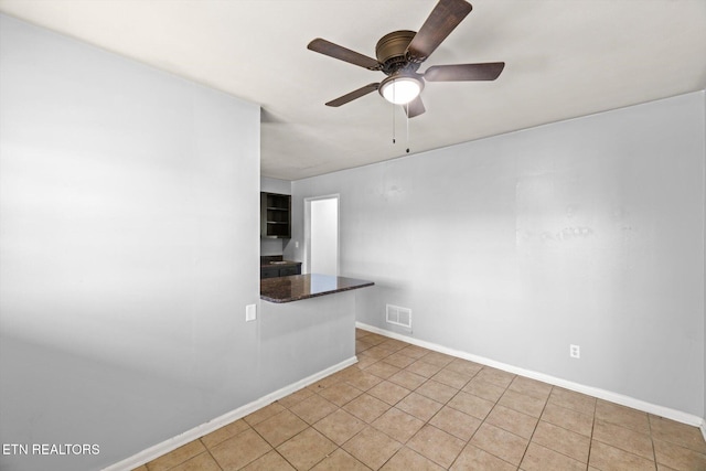 empty room with visible vents, ceiling fan, baseboards, and light tile patterned flooring