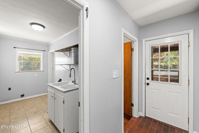 laundry room with baseboards, ornamental molding, brick floor, hookup for an electric dryer, and a sink