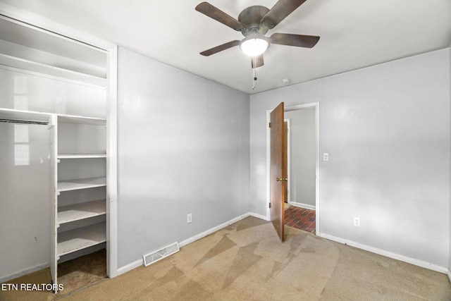 unfurnished bedroom featuring ceiling fan, carpet floors, visible vents, baseboards, and a closet