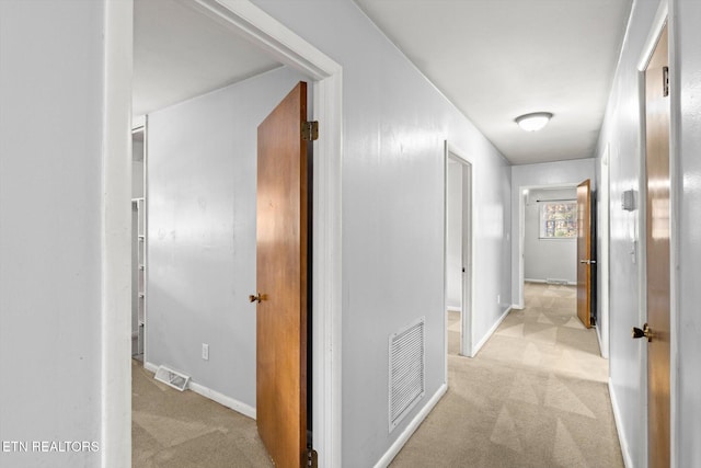 corridor featuring carpet flooring, visible vents, and baseboards