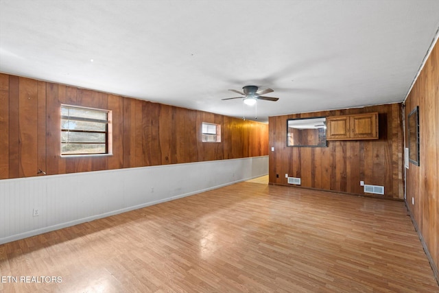 unfurnished room with light wood-style flooring, plenty of natural light, and visible vents