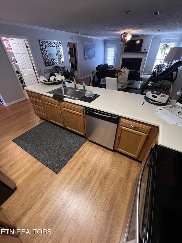 kitchen featuring dishwasher, open floor plan, a sink, and light wood-style flooring