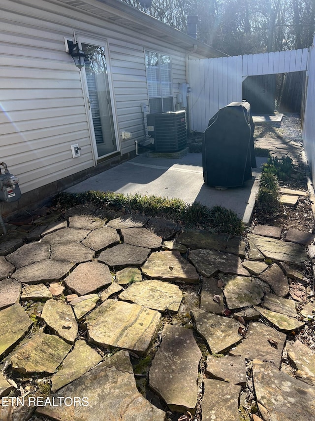 view of patio featuring central AC and fence