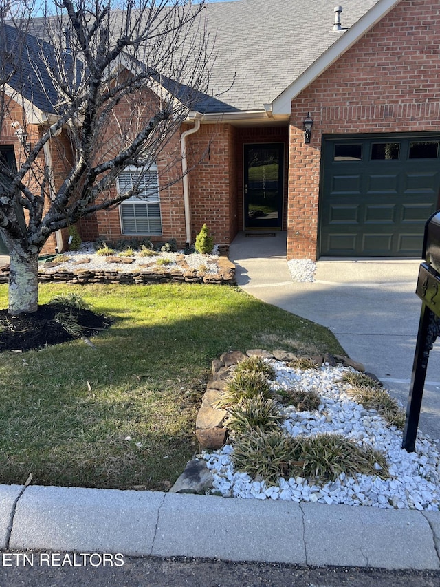 view of front of house with a garage, brick siding, a shingled roof, and a front yard