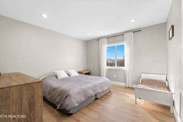 bedroom featuring baseboards, light wood-style flooring, and recessed lighting