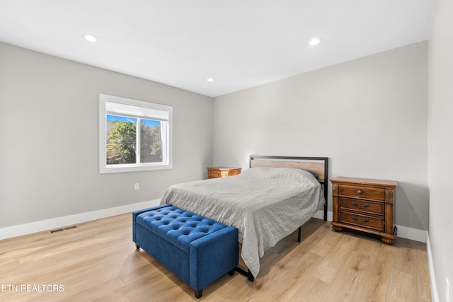 bedroom featuring light wood-style flooring, visible vents, and baseboards