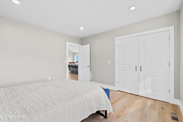 bedroom with recessed lighting, a closet, visible vents, light wood-style floors, and baseboards