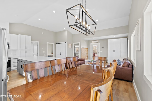 dining room with a barn door, baseboards, lofted ceiling, light wood-style floors, and recessed lighting