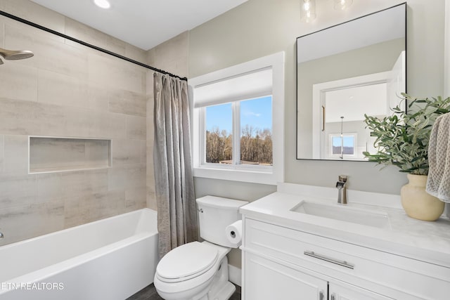 bathroom featuring toilet, shower / bath combo with shower curtain, and vanity