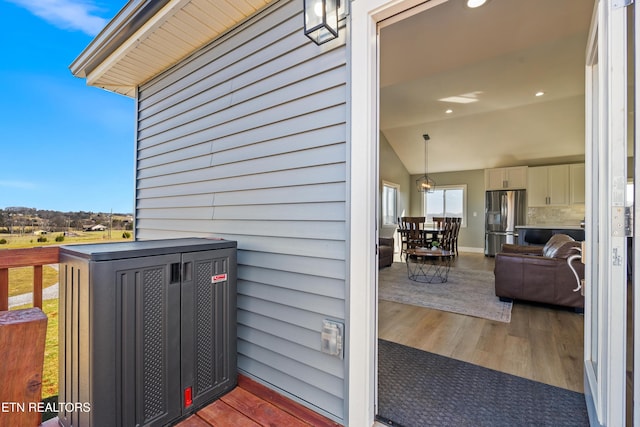 exterior details with central AC unit and stainless steel fridge with ice dispenser