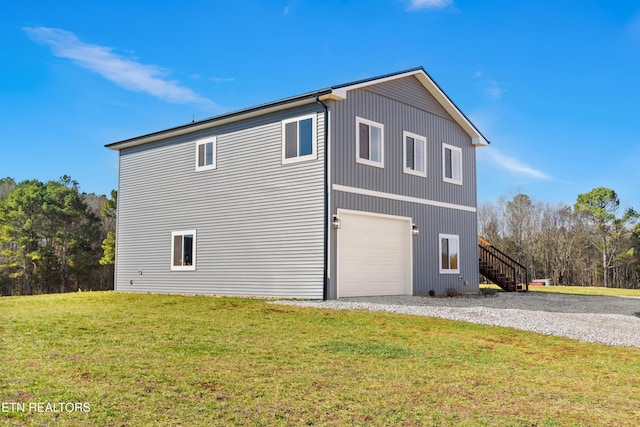 view of side of property with driveway, stairs, and a yard