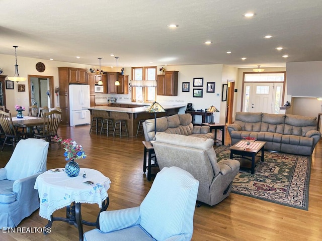 living room with dark wood-style floors and recessed lighting