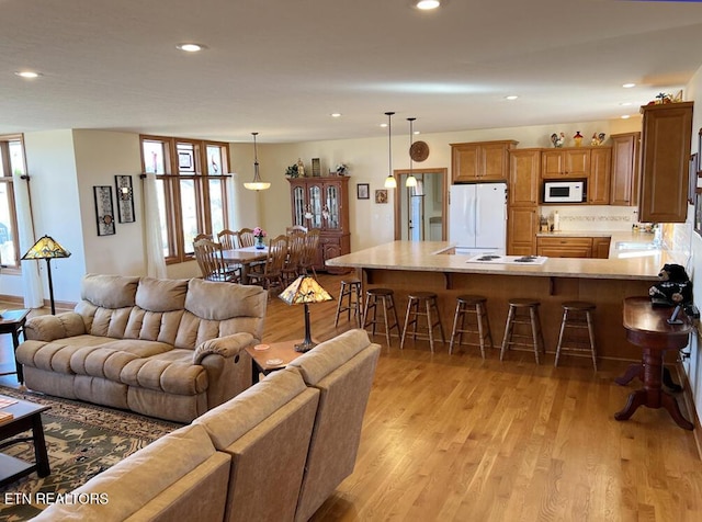 living area featuring light wood-style floors and recessed lighting