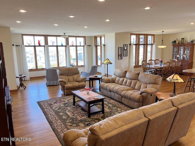 living room featuring recessed lighting, baseboards, and light wood finished floors