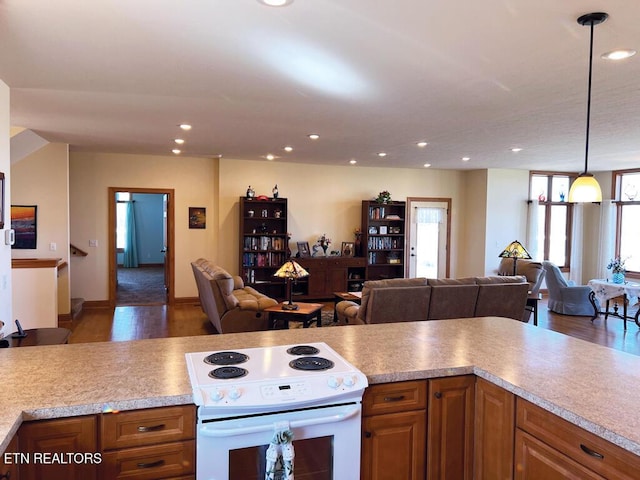 kitchen featuring white electric stove, open floor plan, and brown cabinets