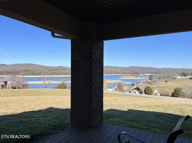 wooden deck with a lawn and a water view