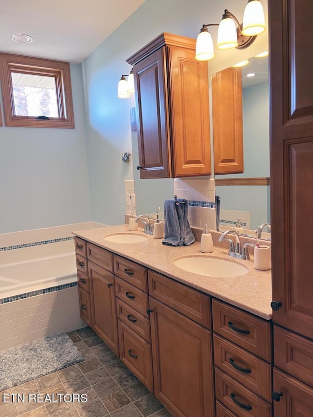 full bathroom with double vanity, a garden tub, and a sink