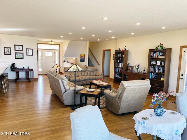 living area featuring light wood finished floors, baseboards, and recessed lighting