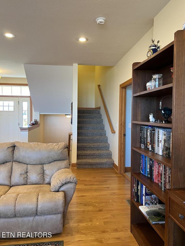 stairs with baseboards, wood finished floors, and recessed lighting