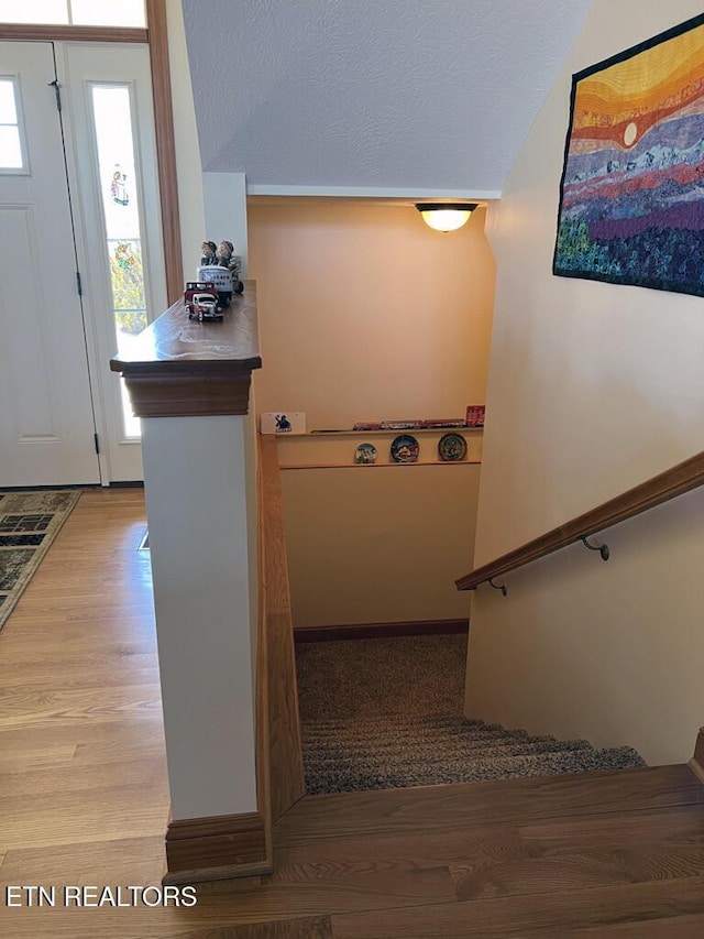 foyer featuring light wood finished floors and a textured ceiling