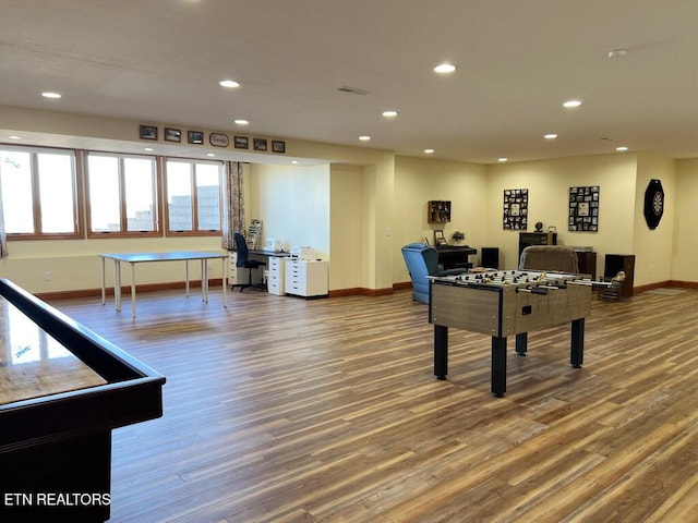 recreation room with baseboards, wood finished floors, and recessed lighting