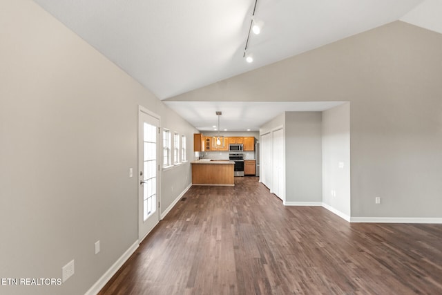 kitchen with brown cabinetry, lofted ceiling, open floor plan, dark wood-style flooring, and stainless steel appliances