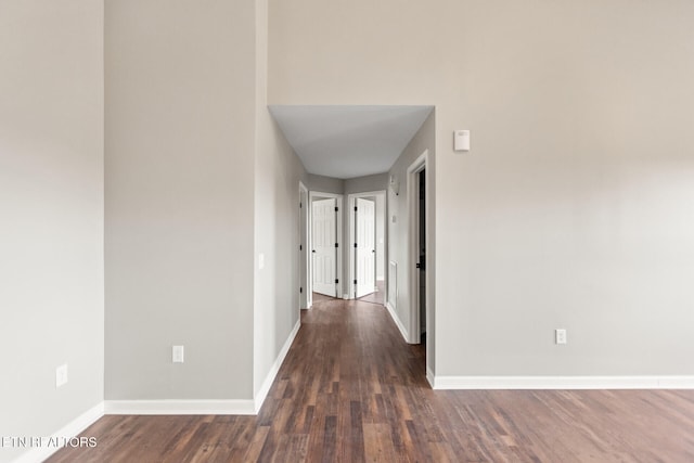 hallway featuring baseboards and wood finished floors